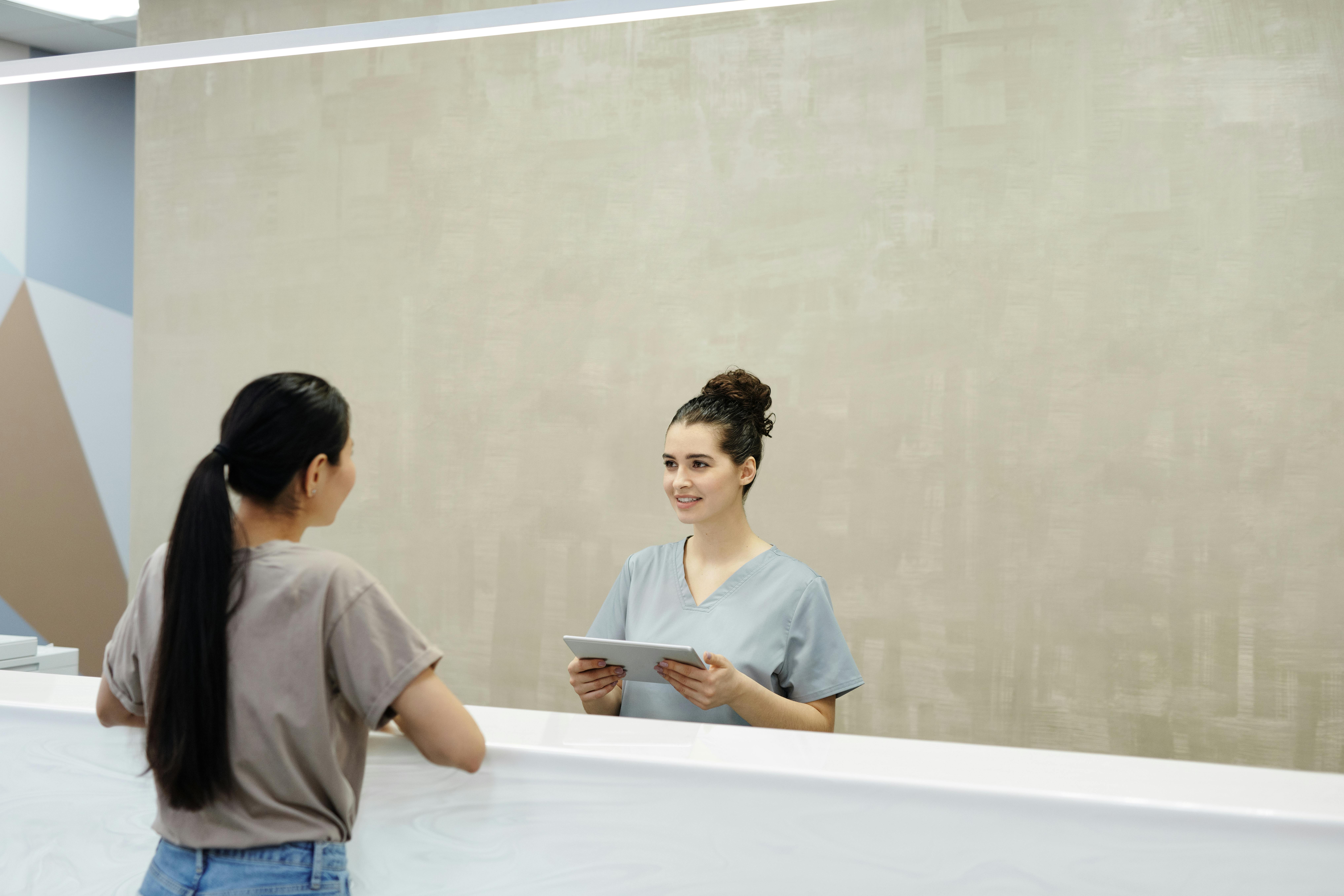A Medical Receptionist Smiling at a Person